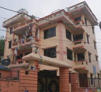 un grand bâtiment avec des drapeaux devant lui dans l'établissement Monkey Bunky-3Monkeys Backpacker's Hostel, à Katmandou