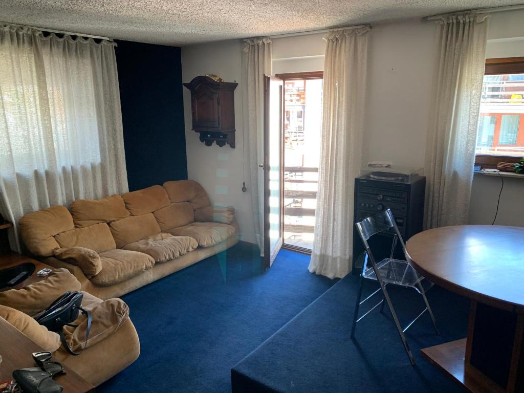 - un salon avec un canapé et une table dans l'établissement Appartamento BREUIL CERVINIA, à Breuil-Cervinia