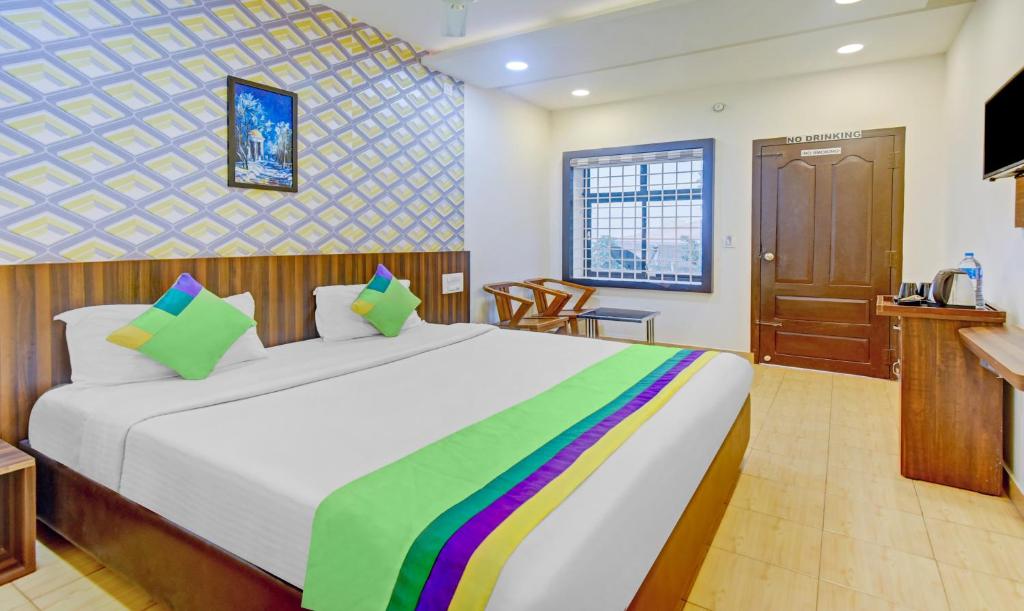 a bedroom with a large bed and a television at Treebo Trend Igloo Residency Raja Seat in Madikeri