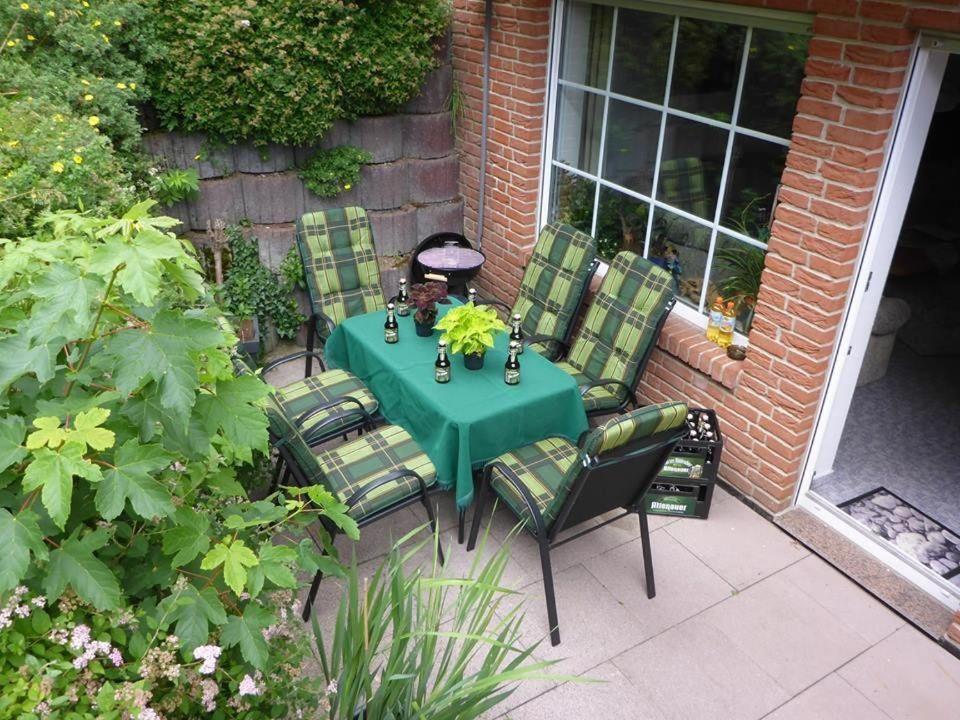 a green table and chairs on a patio at Ferienwohnung-Rita in Altenau