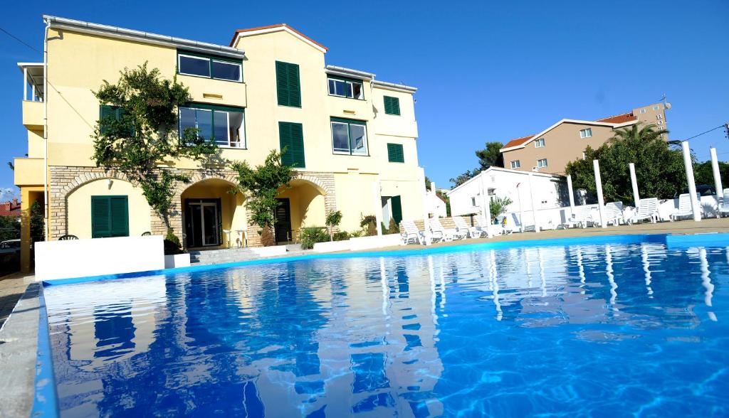 a swimming pool in front of a building at Villa Ani in Novalja