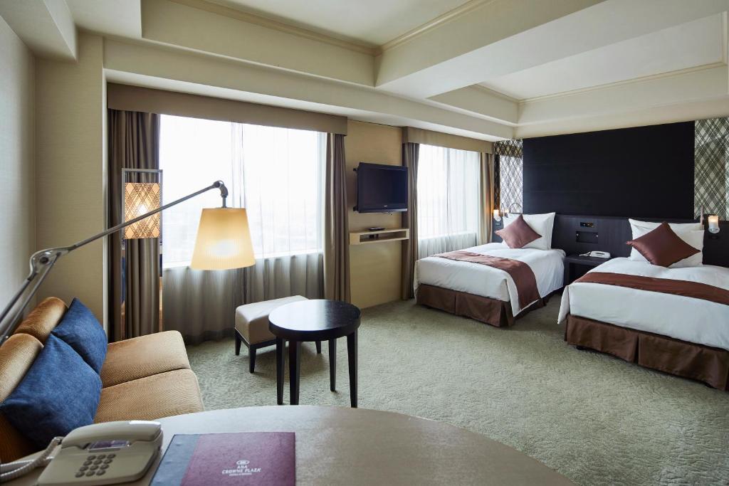 a hotel room with two beds and a table at ANA Crowne Plaza Kanazawa by IHG in Kanazawa