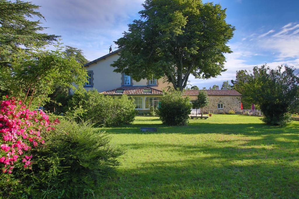 Saint-Romain-de-LerpsにあるVilla Rouvesolの花の庭のある大きな白い家
