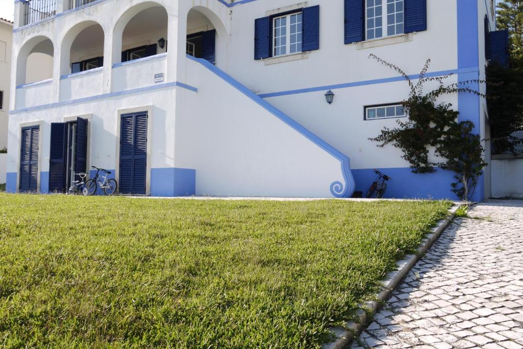 a white house with a blue staircase in front of it at Casa Azul in São Martinho do Porto