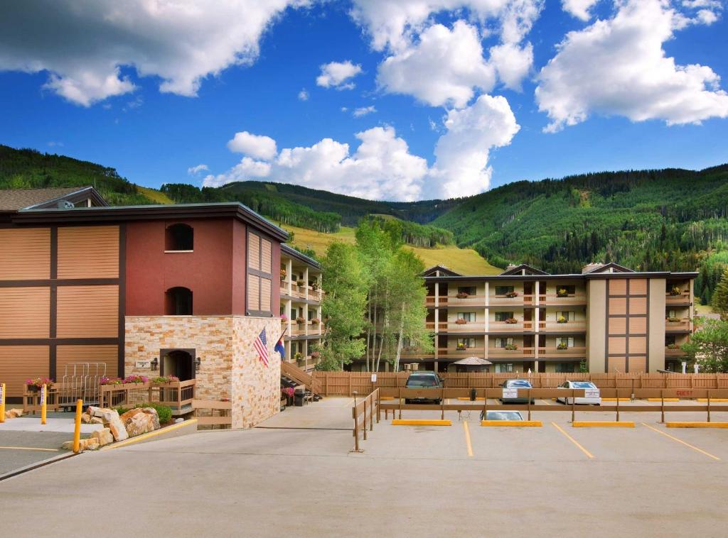 a hotel with a parking lot with mountains in the background at Wren 201 Condo with Vail Mountain View in Vail