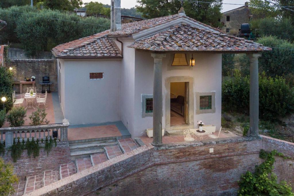 een klein wit huis met een dak bij The Church Experience - San Miniato in Palagio