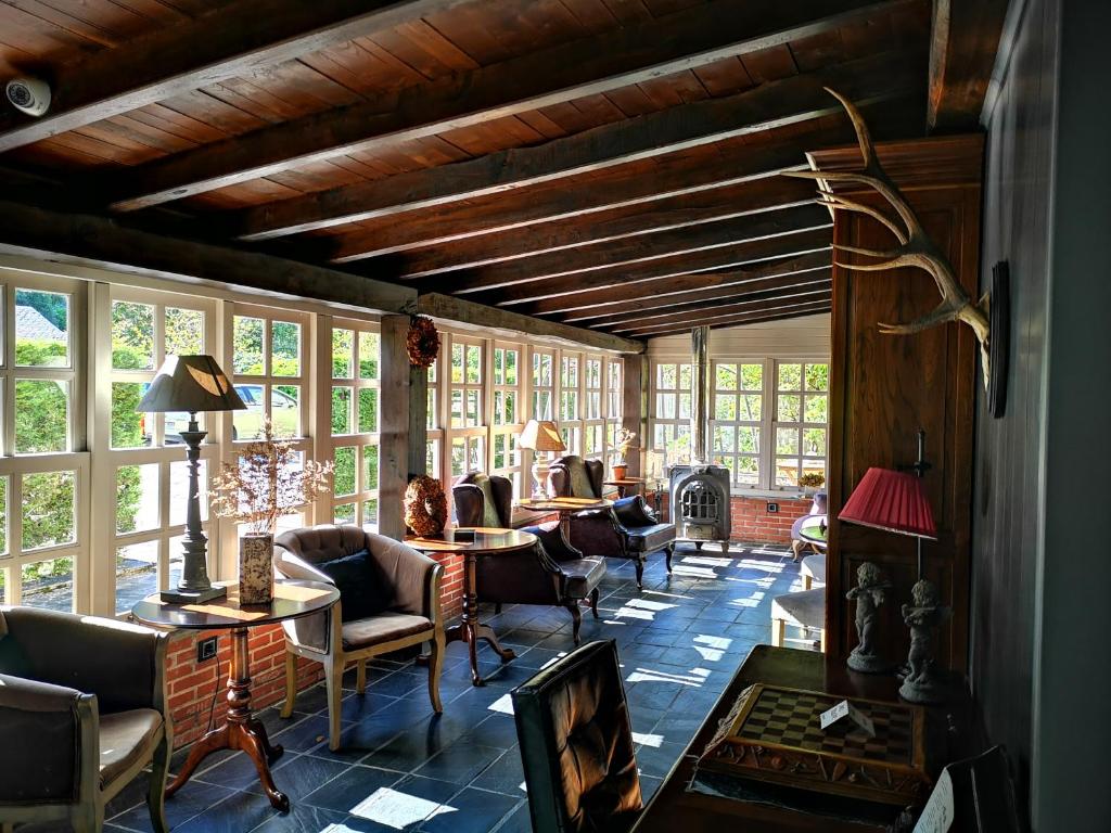 a living room with chairs and tables and windows at Casona Naviega in Navia