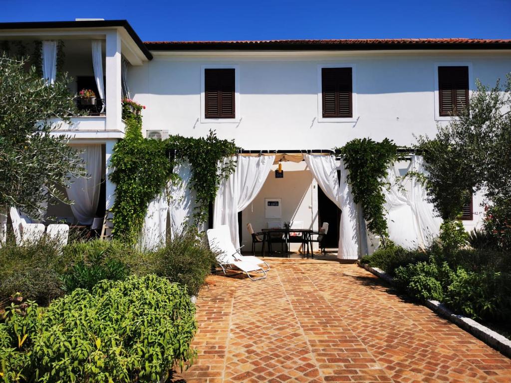 a white house with a red brick walkway at Apartments Relax Zone in Umag