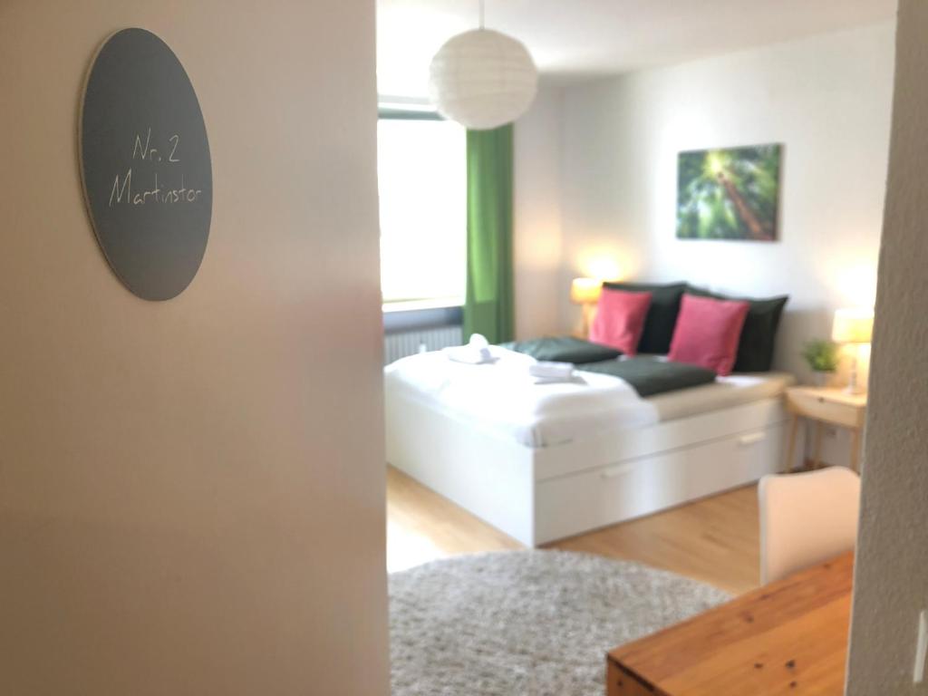 een woonkamer met een witte bank en een bed bij Mida Gästehaus in Freiburg im Breisgau
