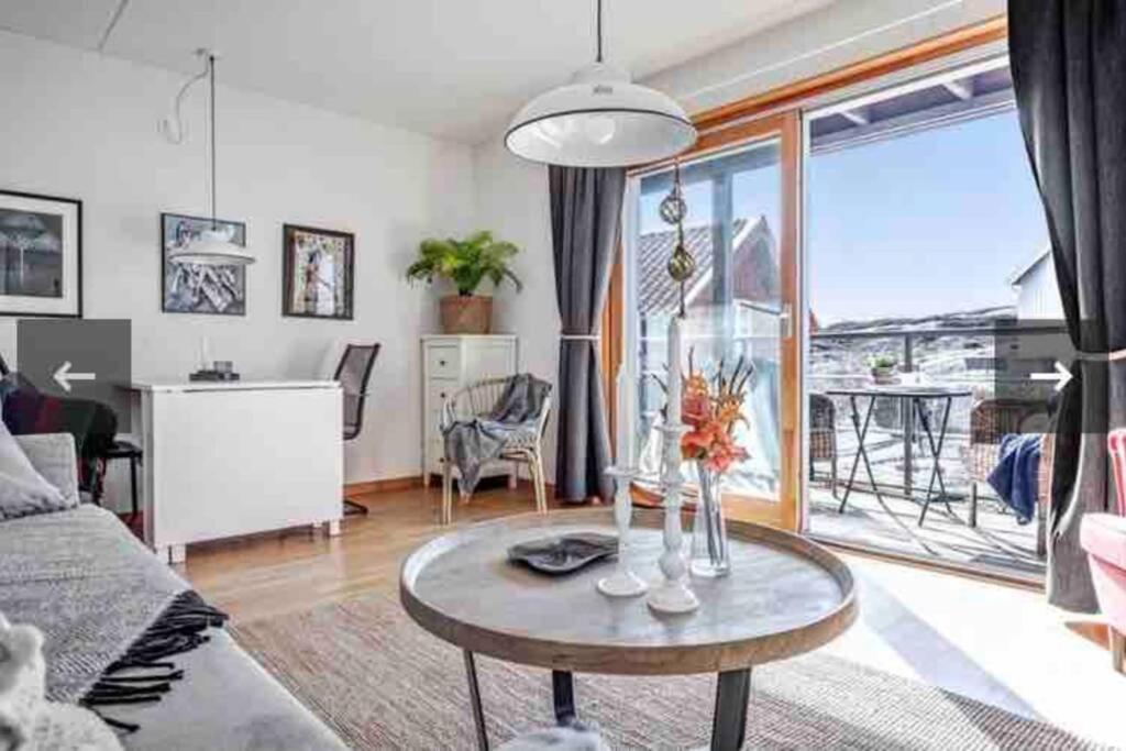 sala de estar con mesa y ventana grande en Egen lägenhet underbara Käringön möjlighet till parkeringsplats en Käringön