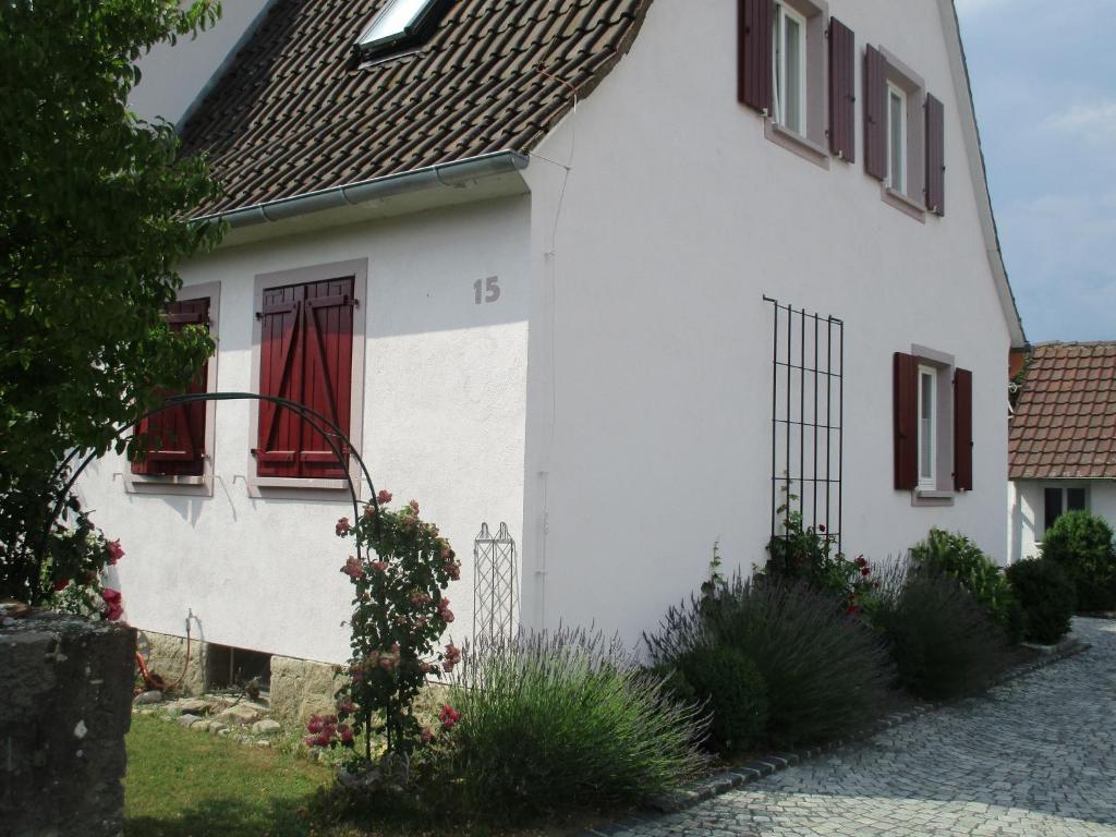 a white house with a red curtain in the window at Haus Fink in Volkach