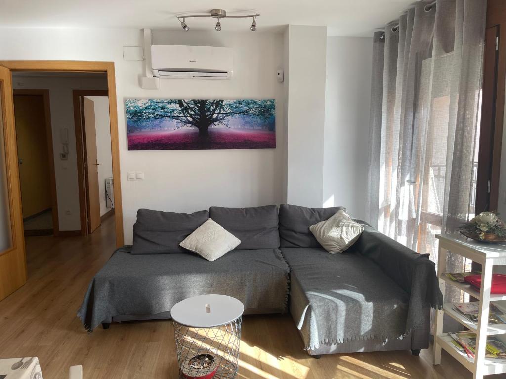 a living room with a couch and a tree on the wall at Piso de Verena in Guardiola de Berguedà
