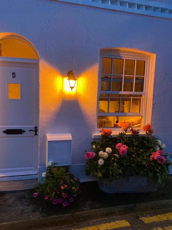 a building with flowers and a door and a window at Stylish & Cosy Boutique Townhouse 1 bedroom, 1 sofa bed - sleeps 4 in Christchurch