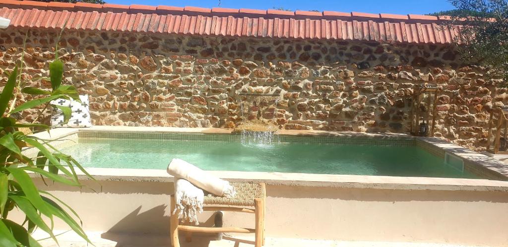 une piscine dans un mur en pierre avec un bon rendement dans l'établissement La parenthèse Thuir piscine privée et chauffée, à Thuir