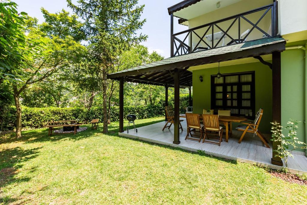 a patio with a table and chairs on a green house at Splendid Villa Surrounded by Nature in Sapanca in Sakarya