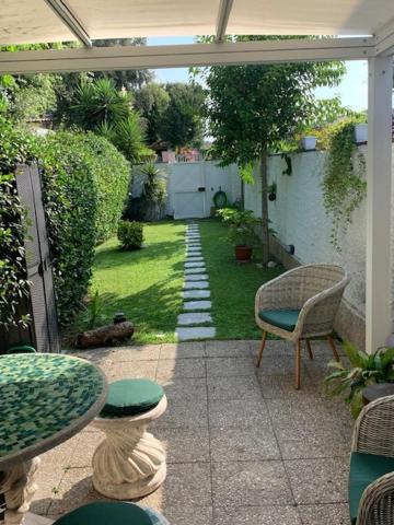 eine Terrasse mit einem Tisch und Stühlen sowie einem Garten in der Unterkunft Casa Celeste Fregene, il mare di Roma in Fregene
