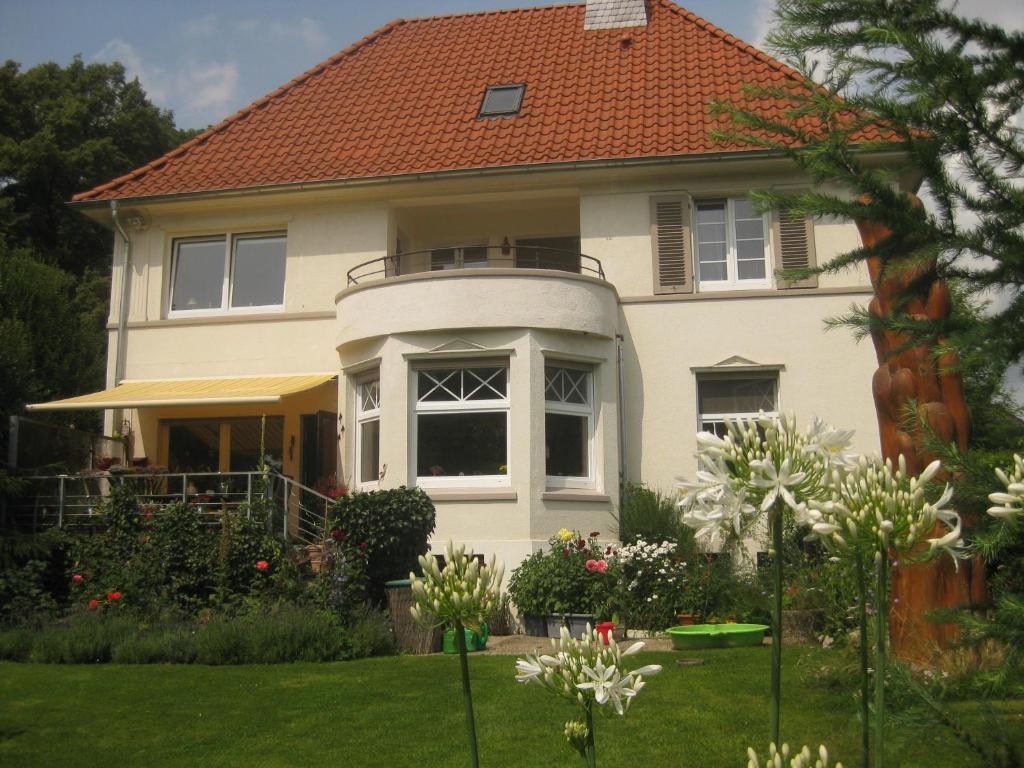 Biały dom z pomarańczowym dachem w obiekcie Haus ReWi w mieście Bünde