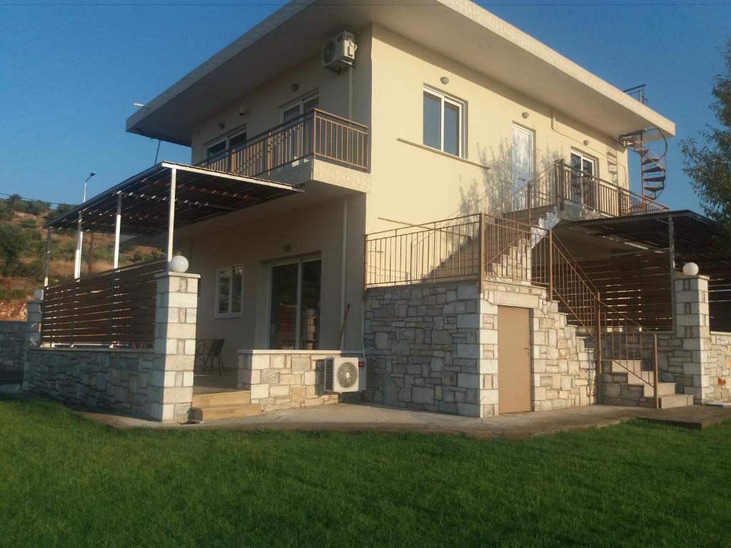 a large house with a balcony and a yard at Nereids Apartments-Agavi in Petalidhion