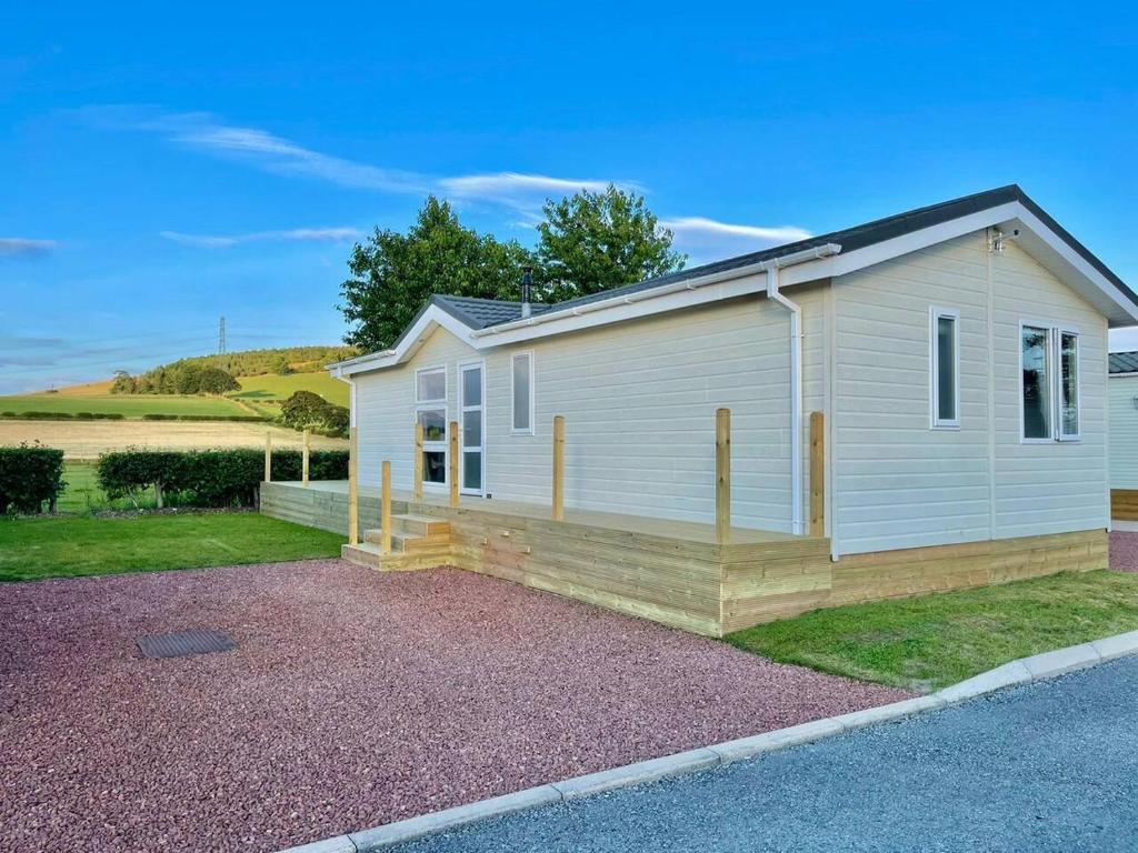 ein kleines weißes Haus am Straßenrand in der Unterkunft Modern House in Carlisle close to Lake District in Carlisle