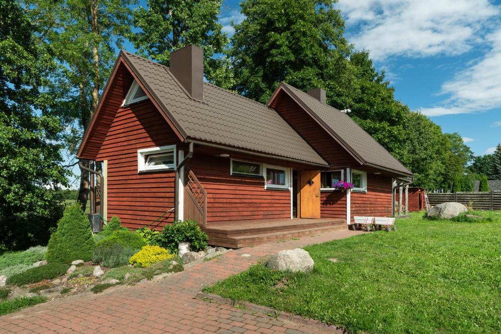 a small red house with a brown roof at Vudila saunamaja in Kaiavere