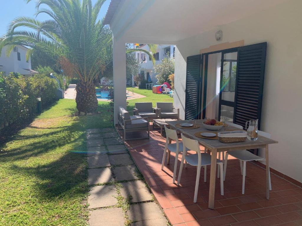 a patio with a table and chairs and a yard at Falésia 25 in Albufeira