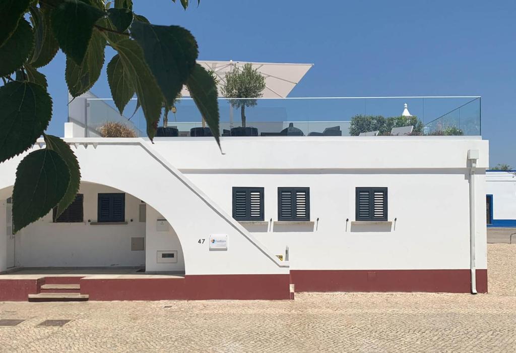 een wit gebouw met een witte deur en ramen bij CasaBlanca - Haus am Meer in Fuzeta