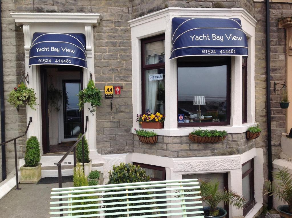 a building with two windows with blue awnings at Yacht Bay View in Morecambe