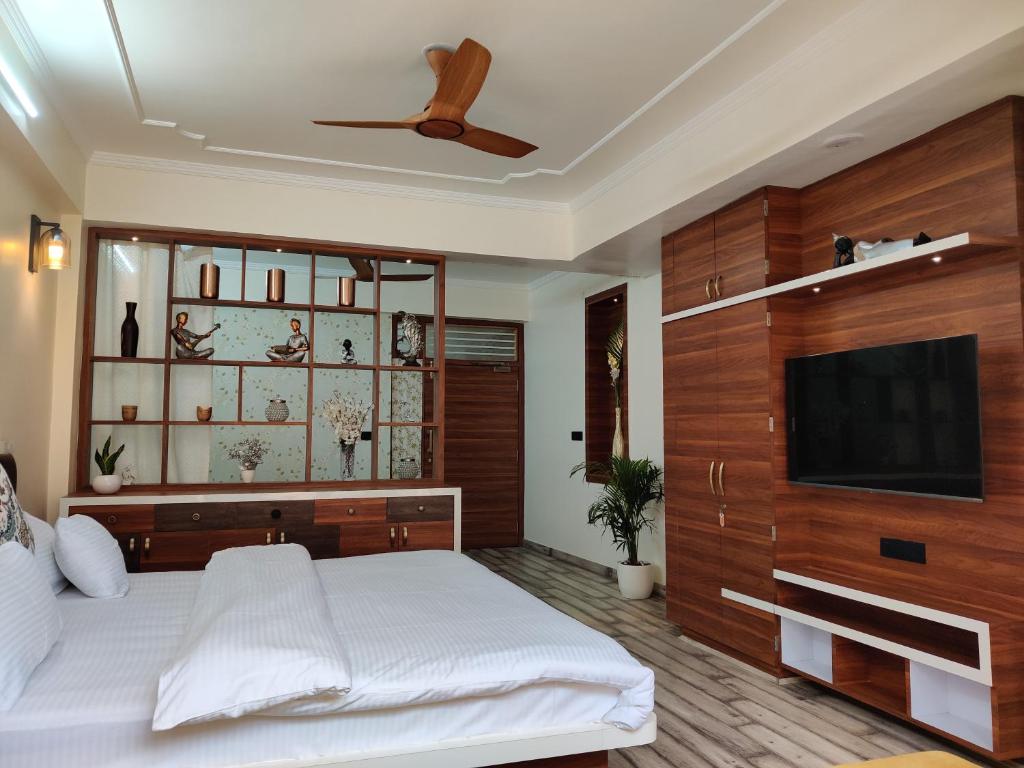 a bedroom with a bed and a flat screen tv at Shanti Villas - Luxury Home Stay Apartment in Jaipur