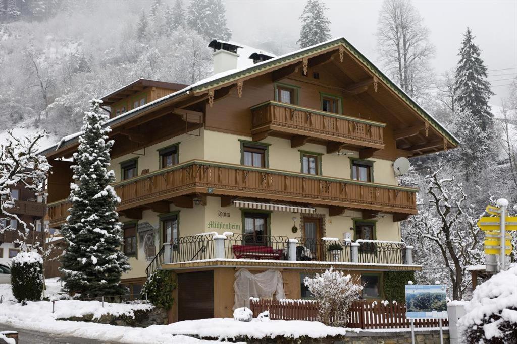 a large house with a balcony in the snow at Haus Mühlenheim in Schwendau