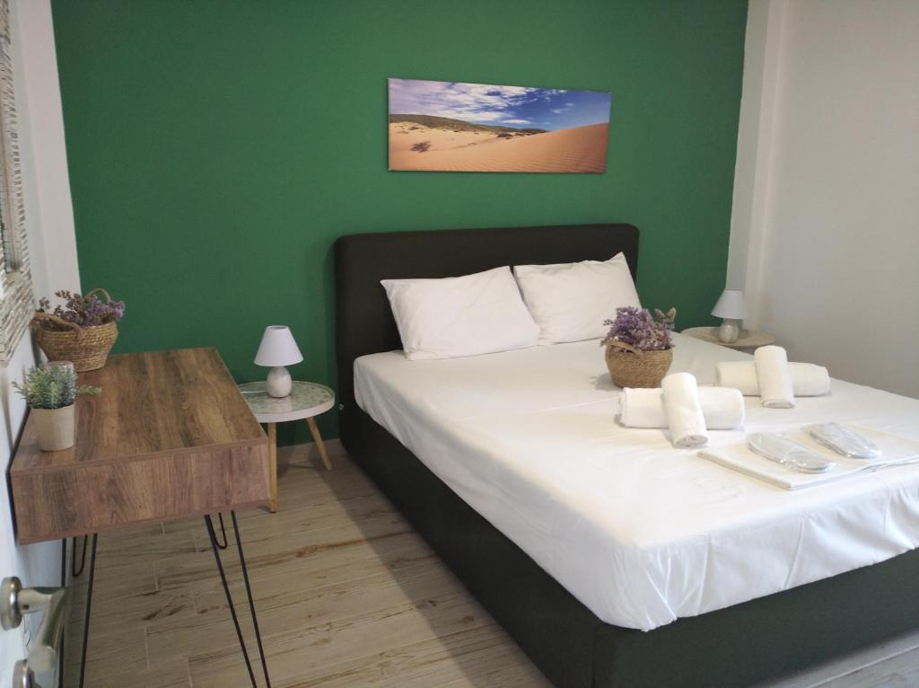 a bedroom with a bed with a green wall at TERRA LEMNIA in Moudhros