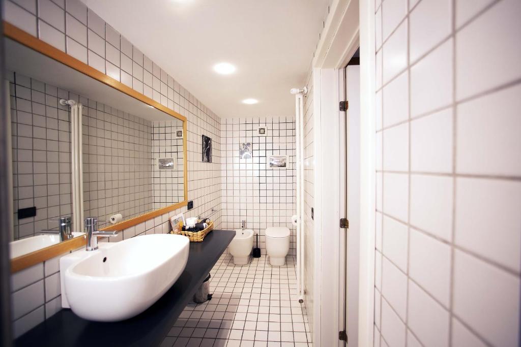 łazienka z dużą białą umywalką i toaletą w obiekcie GeTheKey Borgo Terrace Apartment w Bolonii