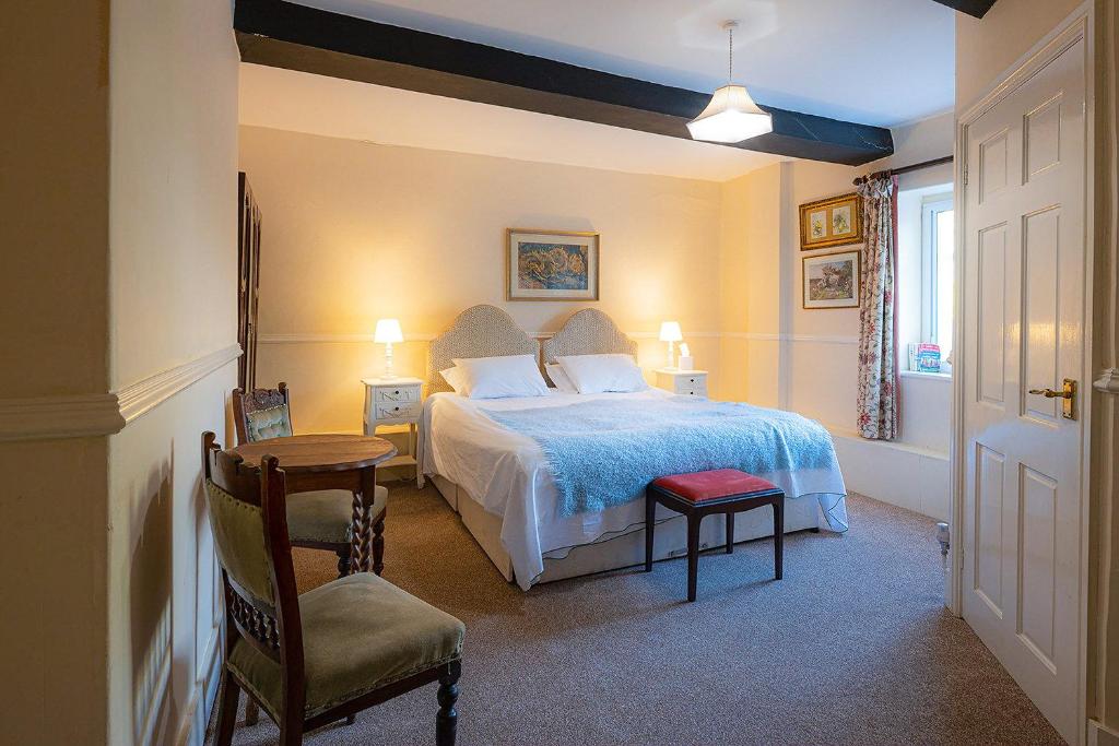 een slaapkamer met een bed, een tafel en een stoel bij The Powis Arms in North Lydbury