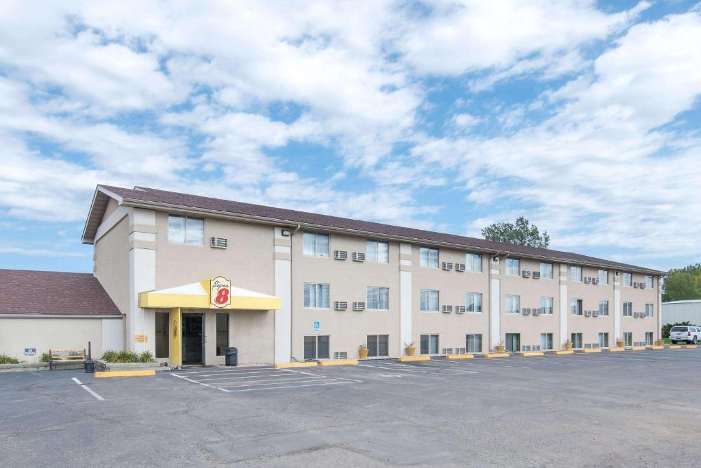 un gran edificio blanco con aparcamiento en Super 8 by Wyndham Watertown, en Watertown
