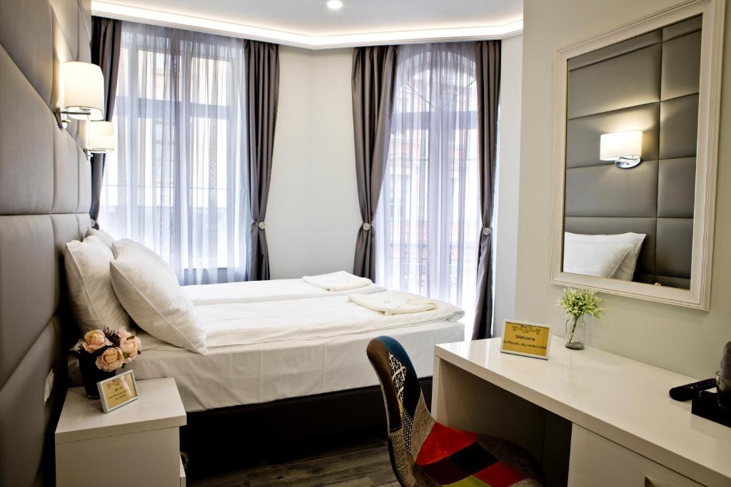 a hotel room with a bed and a mirror at Plovdiv City Center Hotel in Plovdiv