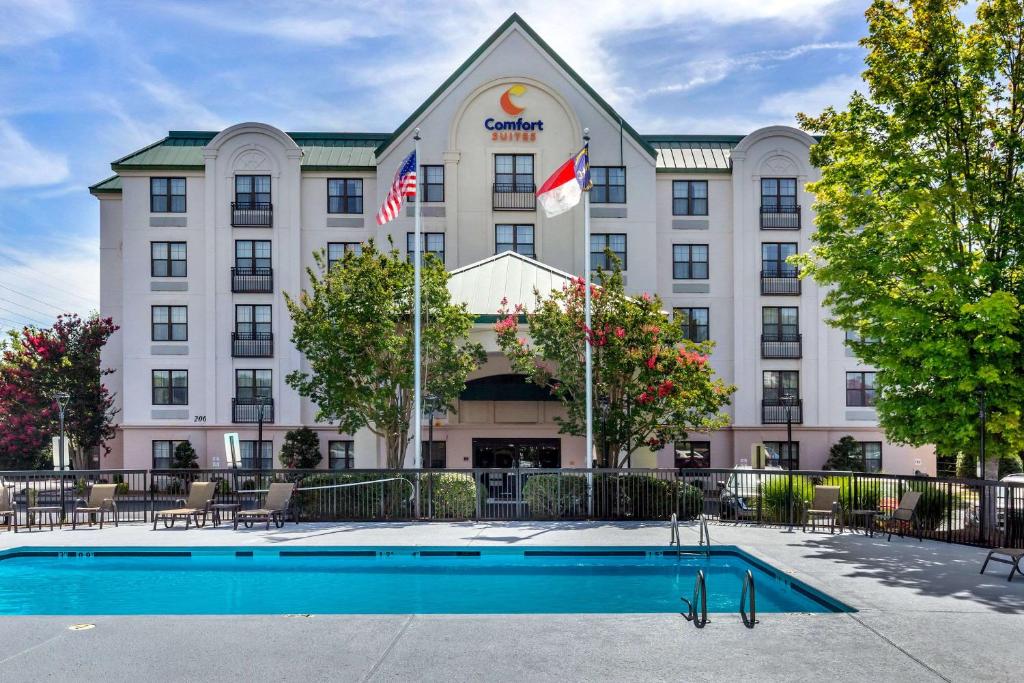 a hotel with a pool in front of it at Comfort Suites Hanes Mall in Winston-Salem