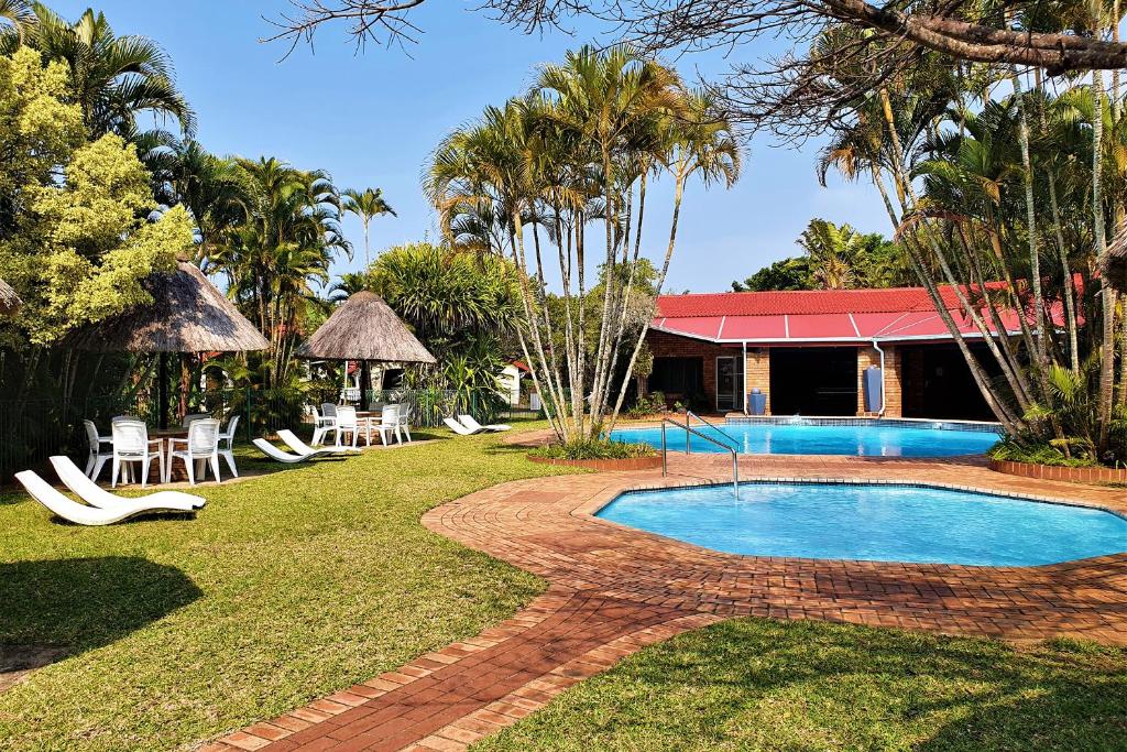 un complejo con piscina, sillas y un edificio en First Group La Rochelle, en St Lucia