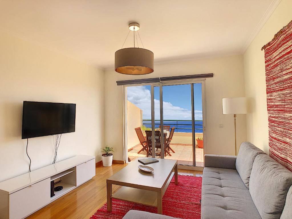 - un salon avec un canapé et une vue sur l'océan dans l'établissement VeBella Ocean View by LovelyStay, à Caniço