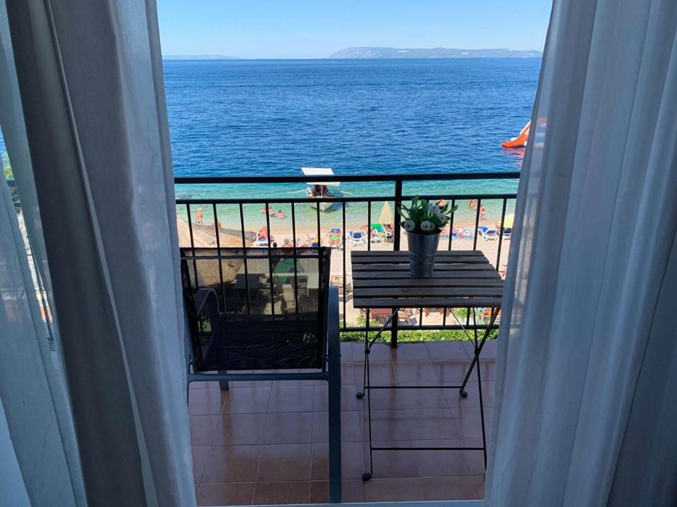 a balcony with a table and a view of the beach at BEACH SEA VIEW APPARTMENT in Podgora