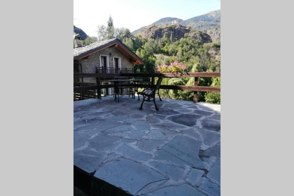 a patio with a table and a view of a house at SWEET TERRACE in Arvier