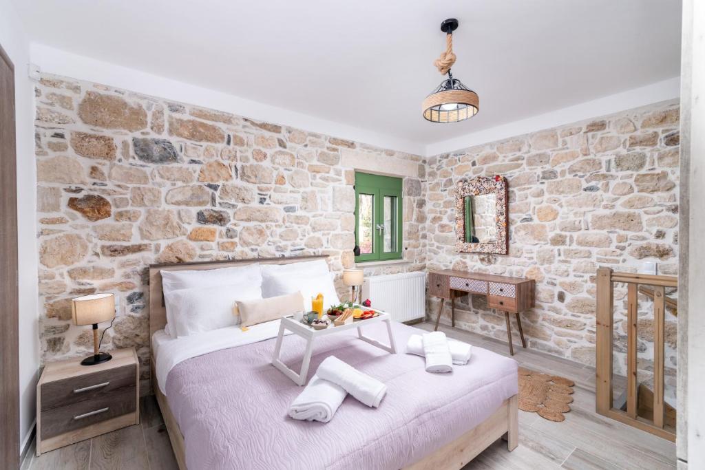 a bedroom with a bed and a stone wall at Katina's House in Petrokefálion
