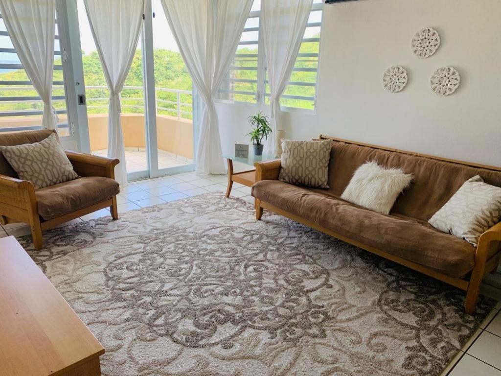 a living room with a couch and two chairs at Coastal View Apartment in Ceiba
