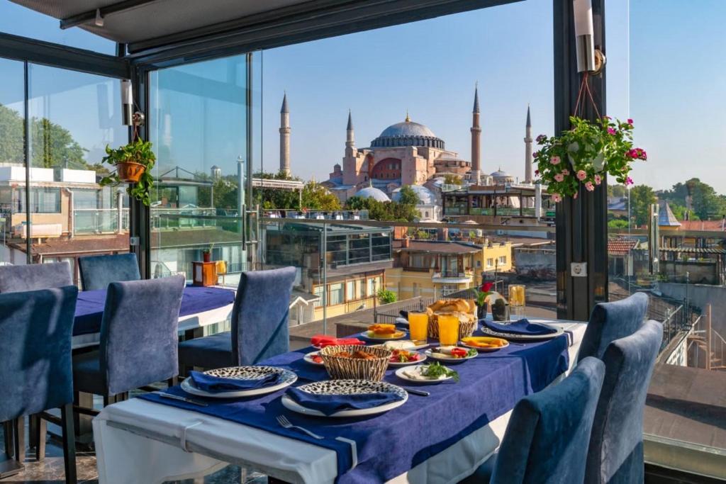 a table with a view of theultan ahmed mosque seen from the balcony at Aristocrat Hotel in Istanbul