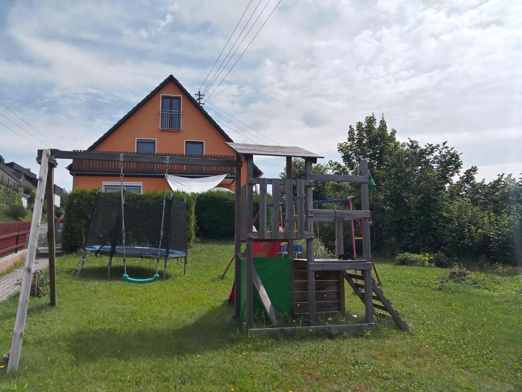 a playground in a yard with a house at Ferienhaus Hilde in Steinwiesen