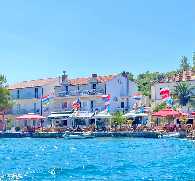 a large body of water with chairs and umbrellas at Guesthouse Gradina in Lovište