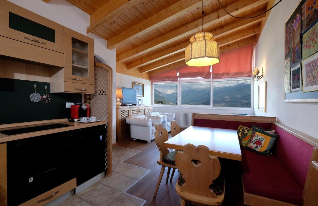 a kitchen with a table and chairs and a dining room at Residenza Bagni & Miramonti in Cavalese