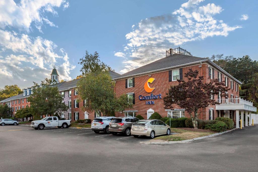 un gran edificio de ladrillo rojo con coches aparcados en un aparcamiento en Comfort Inn Foxboro - Mansfield, en Foxborough