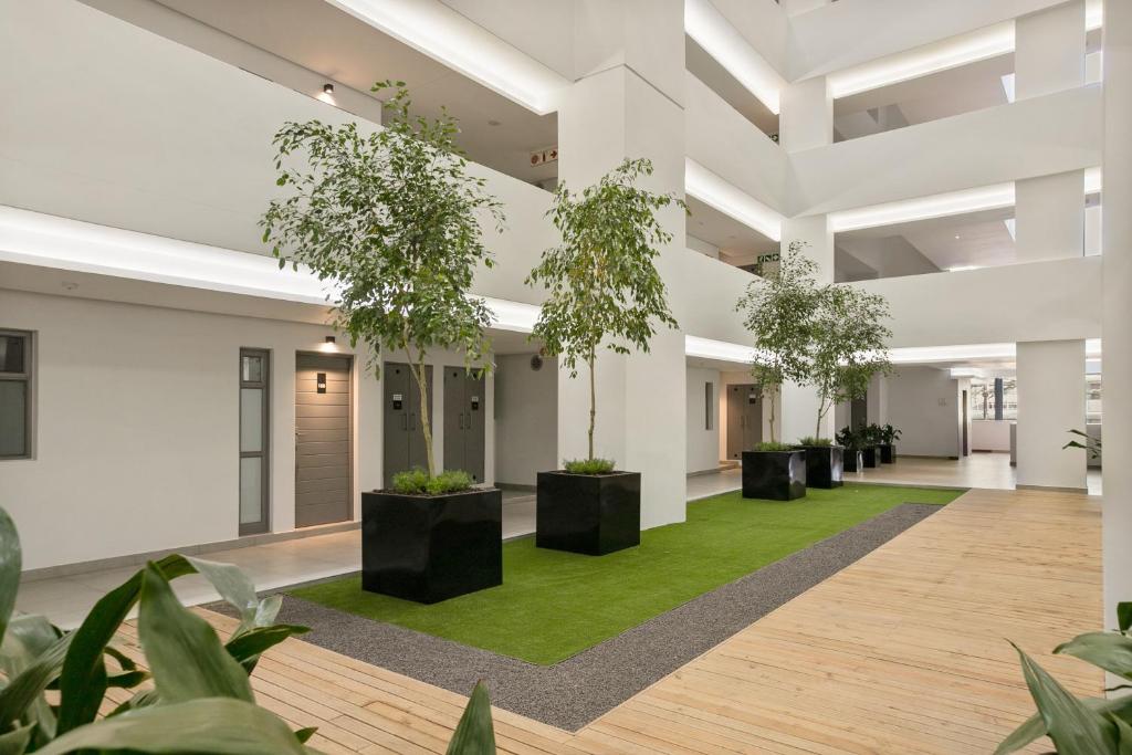 an empty lobby with plants in the middle at The Median Apartments in Johannesburg