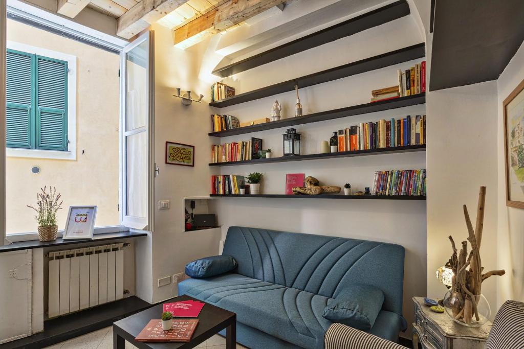 a living room with a blue couch and bookshelves at Santina's House by Wonderful Italy in Genoa