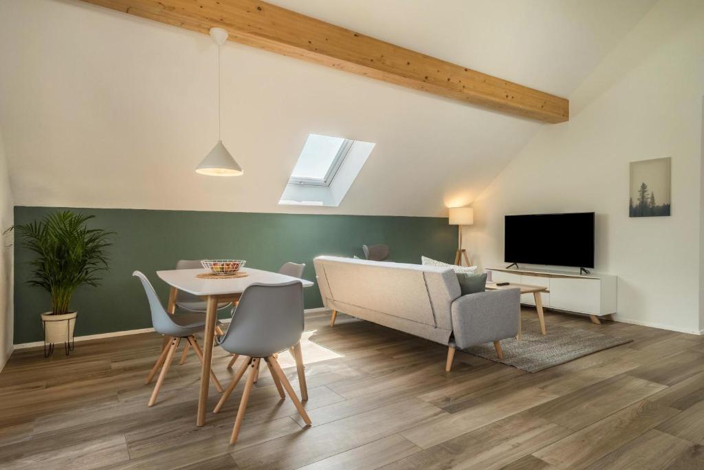 a living room with a table and chairs and a tv at Ferienwohnung Marla in Eriskirch