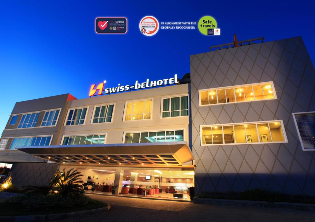 un bâtiment avec un panneau sur son côté dans l'établissement Swiss-Belhotel Kendari, à Kendari